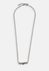 Colar de metal com corrente em tom prateado, apresentando um pendente decorativo com letras intrincadas. Comprimento ajustável com fecho.