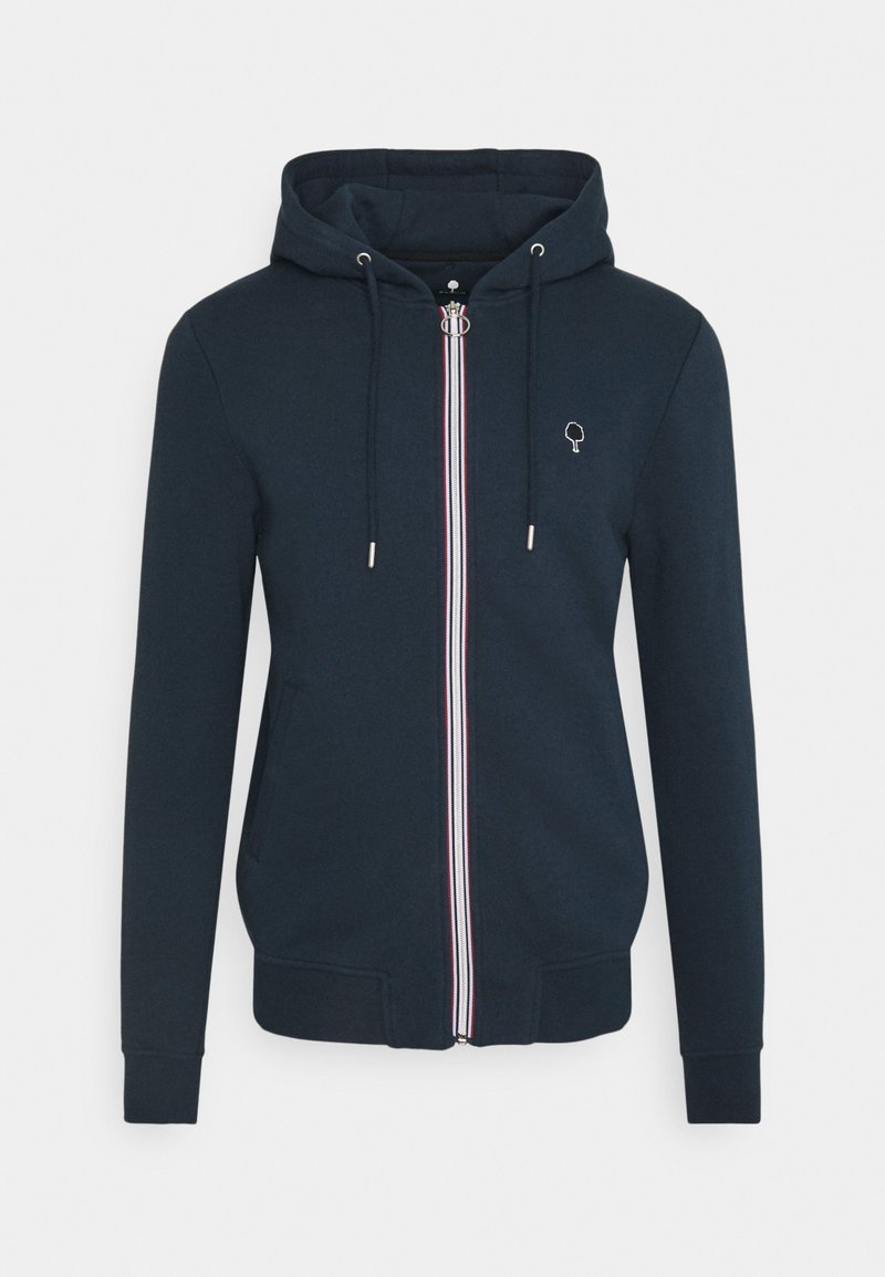 Felpa zip con cappuccio di colore blu navy, dotata di tasca frontale e coulisse. Presenta strisce di accento bianche, rosse e blu lungo la zip. Ha un piccolo logo sul petto.