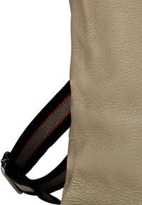 Sac en cuir beige avec une surface texturée, doté d'une sangle noire ornée de rayures rouges et grises. Design minimaliste, sans accents supplémentaires.