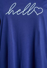 Camiseta azul marino de manga corta con texto "hello" en cursiva de color azul claro y un detalle de corazón, confeccionada con tela suave.