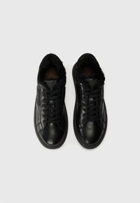 Adidași din piele neagră cu căptușeală din blană sintetică, vârf rotund, design cu șireturi și suprafață texturată. Talpa este plată și din cauciuc.