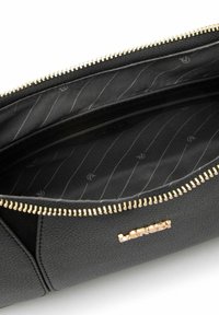 Borsa in pelle nera con texture e cerniera dorata. Interno foderato in tessuto nero con un motivo a strisce sottili e dettagli del logo.