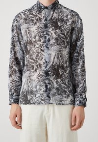 Camicia a maniche lunghe in tessuto trasparente con un motivo a vortice in nero, grigio e bianco, dotata di bottoni frontali e colletto classico.