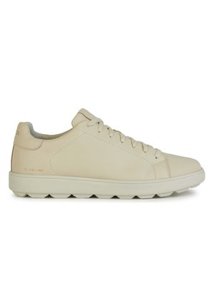 Zapatillas de cuero beige con una textura suave, punta redonda y suela plana con segmentos elevados y redondeados. Diseño con cordones y una marca mínima.