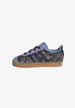 Blue and navy sneaker with floral embroidery, rubber sole, and three dark stripes on the side. Features a padded collar and textured fabric.