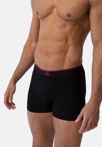 Svarta boxershorts i mjukt tyg med en åtsittande design. Har en röd och svart midjeresår med en logodetalj.