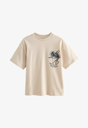 Béžové tričko s krátkym rukávom s čiernou palmou a francúzskym textom "Se relaxer sous les palmiers" na ľavej strane hrude.