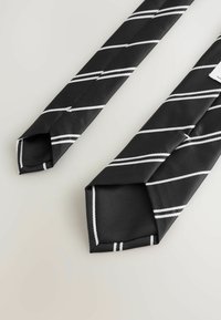 Black tie with diagonal white stripes, made of textured fabric. Features a pointed tip and a loop for secure fastening.