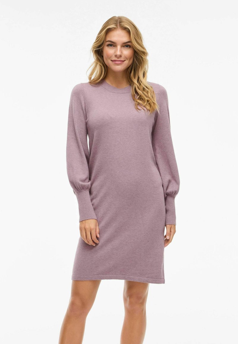 Robe en tricot de couleur lavande clair. Présente des manches longues à ballon et une coupe décontractée. Texture lisse avec un col rond et des poignets côtelés.
