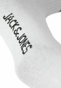 Witte katoenen sokkenmix met een zwart gebreid logo "Jack & Jones" aan de buitenkant. Gladde textuur en klassiek enkelontwerp.