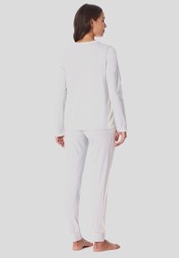 Set di abbigliamento da casa grigio chiaro composto da una maglietta a maniche lunghe e pantaloni abbinati con dettagli a costine sui lati e polsini elastici.