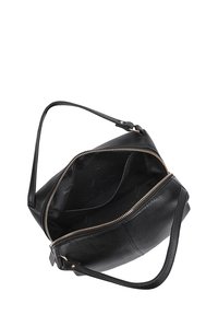 Zwarte leren handtas met een enkele schouderband, ritssluiting en een ongevoerd interieur. Heeft een ronde vorm en minimaal hardware.