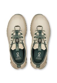 Hellebeige wasserdichte Schuhe mit grünen Akzenten, ausgestattet mit einem strukturierten Obermaterial, elastischen Schnürsenkeln und einem sicheren Sitz durch einen Toggle-Verschluss.