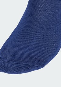 Granatowa skarpeta o ribbowanej fakturze i gładkim wykończeniu, z wzmocnioną częścią palców oraz zakrzywionym kształtem dla wygody noszenia.