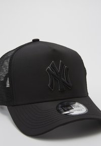 Schwarze Baseballmütze mit strukturiertem Design, ausgestattet mit einem Netzrücken, einem gestickten Logo vorne und einem flachen Schirm. Verstellbarer Snap-Verschluss.