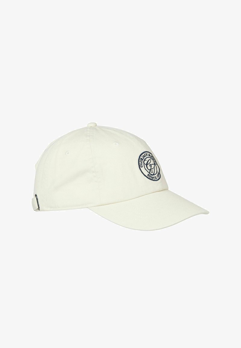 Gorra de béisbol color blanco hueso con visera curva, correa ajustable y parche circular negro en la parte frontal con el texto "CULT JACK & JONES DESDE 1989".