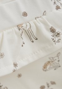 Baumwollstoff in einem hellen Cremeton, mit gedruckten Blumen- und Tiermustern in sanften Brauntönen; umfasst ein gerafftes Taillenbund-Detail.
