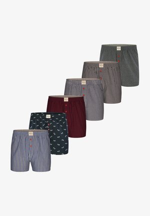 Sieben Paare Boxershorts in verschiedenen Designs: gestreift, kariert und gemustert. Die Farben umfassen Marineblau, Rot, Grau und Weiß, mit Knöpfen und einem weichen Bund.