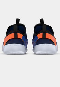 Mørkeblå sportsko med oransje detaljer, svart innside og hvite såler. Har en løkke bak på hælen og strukturerte sidepaneler.