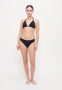 Ensemble bikini noir avec un haut triangulaire et un bas assorti, doté de détails brodés, d'une texture lisse et de bretelles réglables.