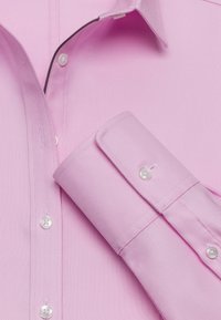 Rosa strukturiertes Hemd mit Button-Down-Kragen, weißen Knöpfen und kontrastierenden schwarzen Nähten entlang des Kragens und der Manschette.
