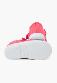Sneakers in tela rosa con suola in gomma bianca texturizzata, dotati di una fascia in Velcro per la chiusura e un design cucito sul lato.