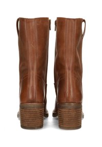 Botas de tobillo de cuero marrón con una textura suave, dos cremalleras laterales y tacones de madera apilados, que presentan un diseño sencillo y costuras verticales.