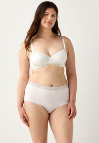 Bra bianco con bordi in pizzo e mutandine alte coordinate. Tessuto morbido con una consistenza liscia. Il design presenta delicati dettagli in pizzo.