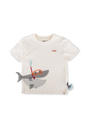 T-shirt bianca da bambino con logo sigikid arancione e uno squalo a cartone animato con attrezzatura da snorkeling arancione, più un piccolo ciondolo di balena blu.