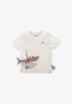 T-shirt bianca da bambino con logo sigikid arancione e uno squalo a cartone animato con attrezzatura da snorkeling arancione, più un piccolo ciondolo di balena blu.