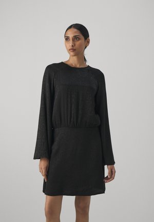 Black dress with long sleeves, textured pattern, rounded neckline, gathered waist, and a relaxed fit. Smooth fabric with slight sheen.
