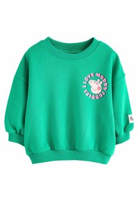 Felpa verde con colletto rotondo, maniche a sbuffo e una grafica circolare che raffigura un maiale con il testo "Adoro i pozzetti fangosi."