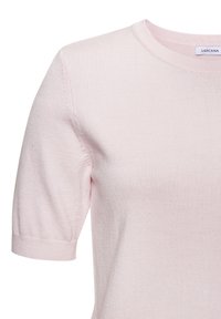 Svetloružový krátky pletený top s rebrovaným okrúhlym výstrihom a manžetami, s jemne nafúknutými rukávmi.