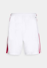 Shorts de sport blancs avec une ceinture élastique et des bandes verticales rouges sur les côtés sur un fond uni.