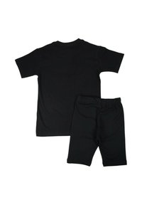 T-shirt en coton noir à manches courtes assorti à un short avec taille élastique. Design simple, texture lisse, sans motifs visibles ni détails métalliques.