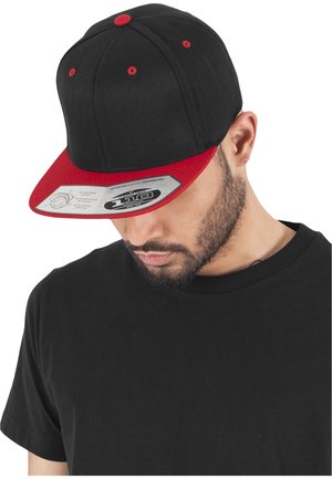 Fekete baseball sapka piros karimával és hangsúlyos elemekkel. Strukturált formával rendelkezik és állítható snapback záródása van. A címke a termék specifikációit mutatja.
