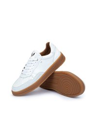 Sneaker bianchi in pelle con punta perforata, suola in gomma marrone e dettagli laterali. Presentano lacci e logo sulla linguetta.