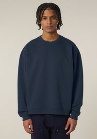 Felpa navy con scollo rotondo e maniche lunghe e larghe. Realizzata in tessuto testurizzato con orlo a costine, offre una vestibilità rilassata.