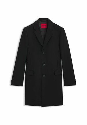 Cappotto nero su misura con rever a notched, cinque bottoni, tasche laterali e polsini abbottonati. Presenta un'etichetta logo rossa all'interno. Tessuto dalla texture liscia.