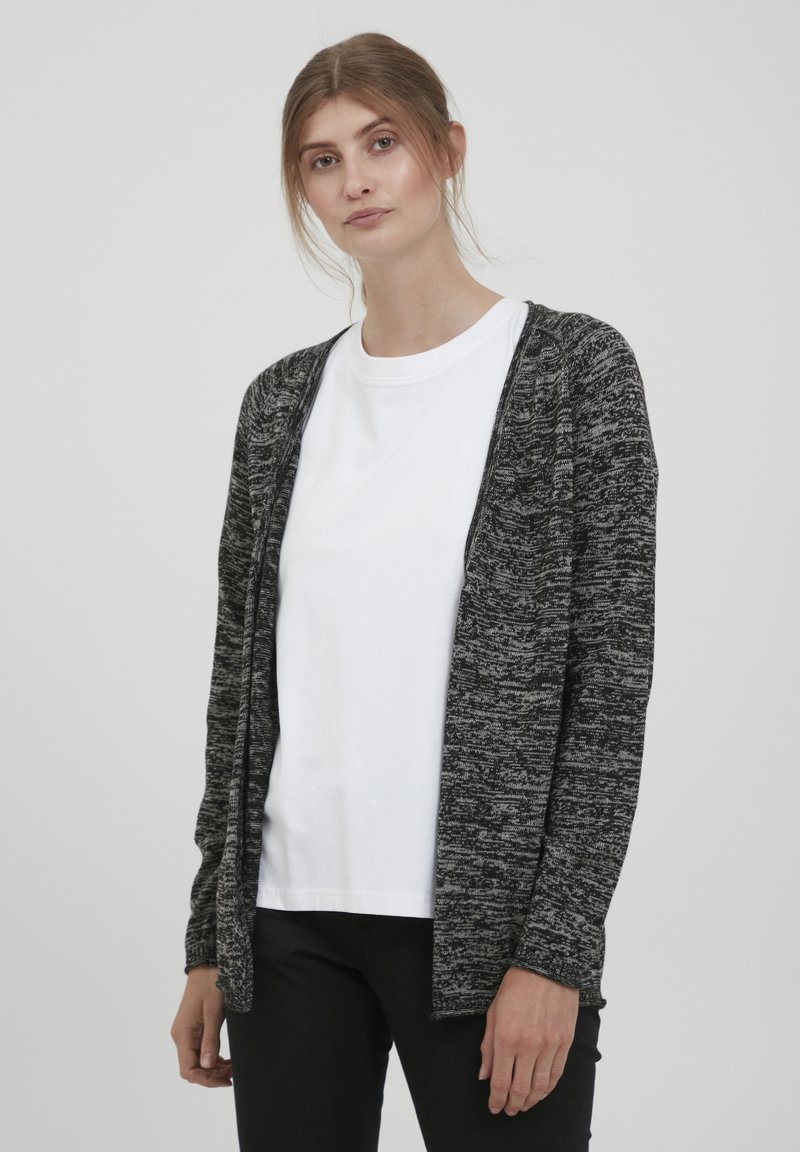 Open-front cardigan in a black and gray marled knit. Long sleeves, relaxed fit, and soft texture. Worn over a white t-shirt.