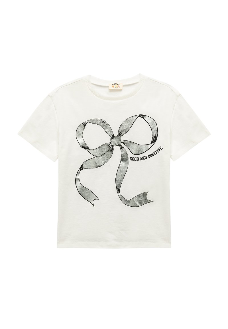 Camiseta de algodón blanca con un gran gráfico de lazo negro y el texto "BUENO Y POSITIVO" debajo. Cuello redondo y mangas cortas.