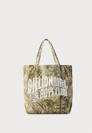 Camouflage-patterned tote bag made of textured fabric with two handles. Features a prominent white logo on one side.