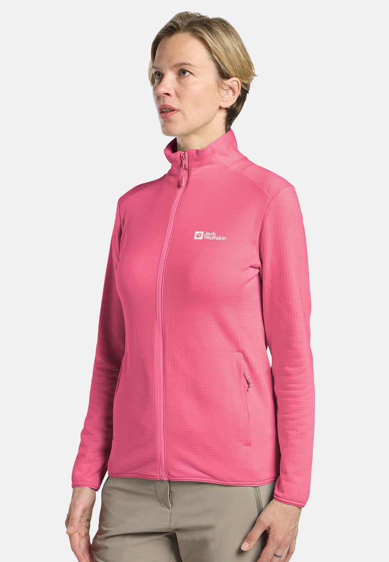 Veste zippée rose en tissu texturé, avec col montant et poches latérales. Présente un logo sur la poitrine gauche.