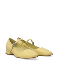 Gelbe Lackleder Schuhe mit niedrigem Blockabsatz, spitzem Schuhkopf und einem Riemen, der mit einer silberfarbenen Schnalle über dem Spann gesichert ist.