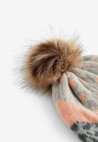 Hallitusbeanie hallis, koralli- ja sinimustritega, ülaosas karvase tan fake fur pom-pom'iga. Pehme tekstuur ja ümar kuju.