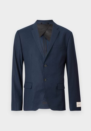 Námořnicky modré sako se dvěma knoflíky, klopovým límcem s zářezem, předními kapsami s klopami a bílou nášivkou na manžetě rukávu.