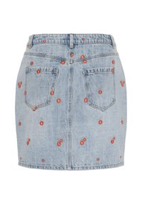 Jupe en denim bleu clair avec broderie de cerises rouges, deux poches arrière et une taille basique. Coupe courte et droite.