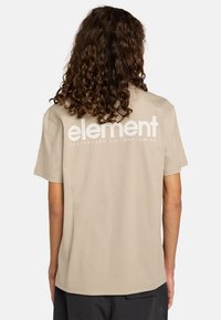 Béžové bavlněné tričko s velkým bílým logem "element" na zádech, krátké rukávy a pohodlný střih.