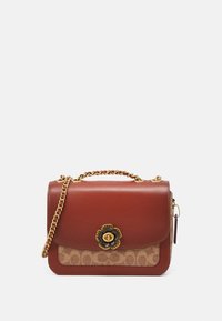 Brązowa skórzana torebka na ramię z złotym łańcuchem, z kwiatową zapięciem i wzorzystą panelą z płótna z przodu. Prostokątny kształt.