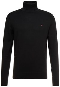 Suéter negro de cuello alto hecho de un tejido suave, con mangas largas y un pequeño logotipo en el pecho. Corte clásico y diseño minimalista.
